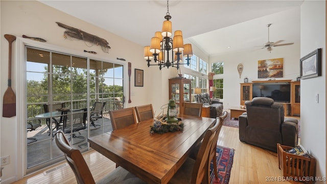 dining space featuring light wood-type flooring and ceiling fan with notable chandelier