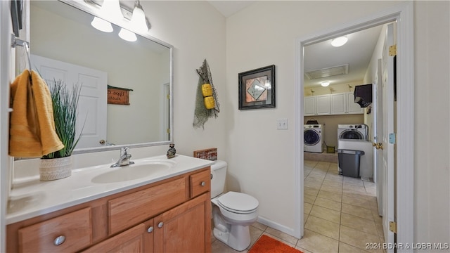 bathroom with washer and clothes dryer, vanity, toilet, and tile patterned flooring