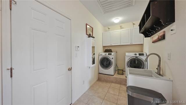 laundry area featuring cabinets, independent washer and dryer, and light tile patterned floors