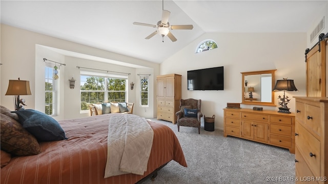 bedroom with a barn door, vaulted ceiling, light carpet, and ceiling fan