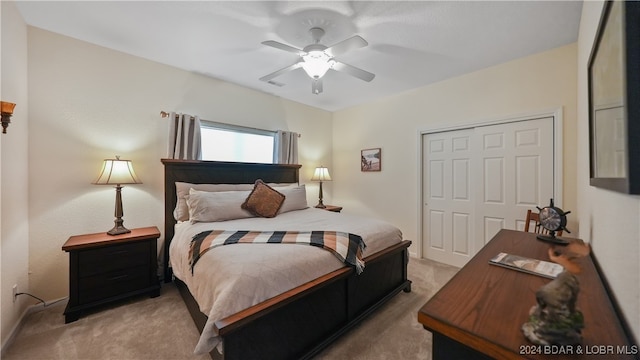 bedroom with ceiling fan, light carpet, and a closet