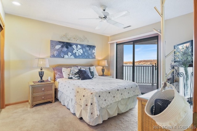 bedroom featuring ceiling fan, a water view, light carpet, and access to outside