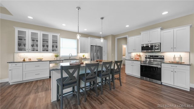 kitchen with sink, hanging light fixtures, dark hardwood / wood-style flooring, white cabinets, and appliances with stainless steel finishes