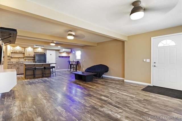 entrance foyer with beam ceiling, a wall mounted AC, ceiling fan, and dark wood-type flooring