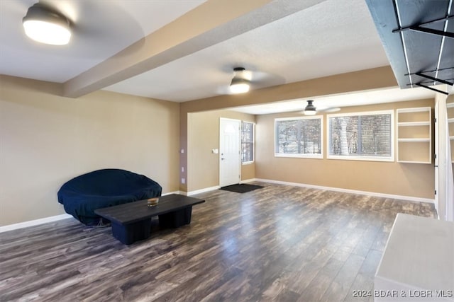 living area with beam ceiling, dark hardwood / wood-style floors, and ceiling fan