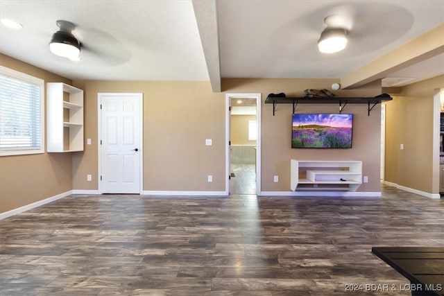 unfurnished living room with ceiling fan and dark wood-type flooring