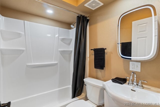 full bathroom featuring sink, shower / bath combo, and toilet