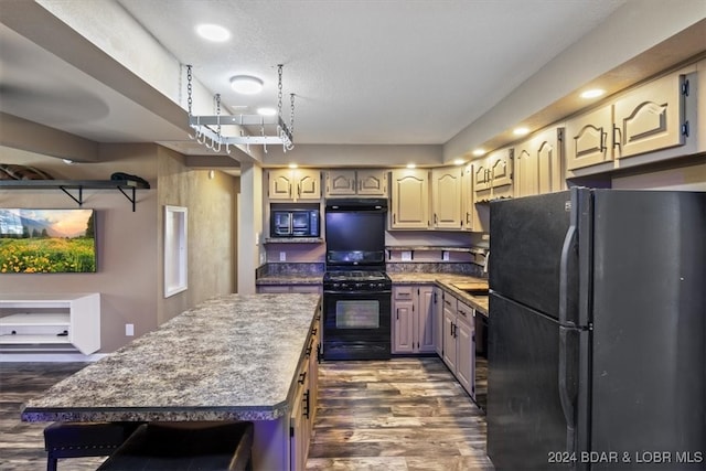 kitchen with black appliances, dark wood-type flooring, and a textured ceiling