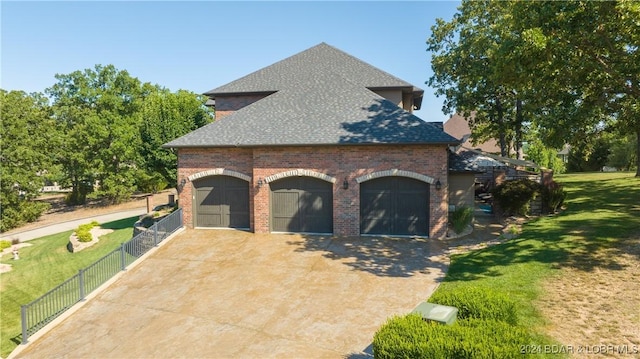 view of side of property featuring a lawn and a garage