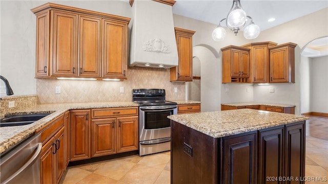 kitchen with tasteful backsplash, hanging light fixtures, stainless steel appliances, sink, and custom exhaust hood