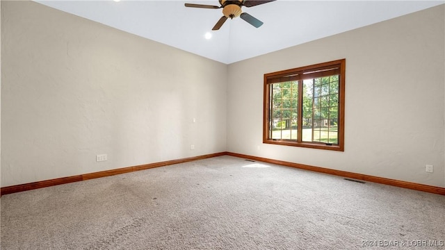 spare room with carpet, vaulted ceiling, and ceiling fan