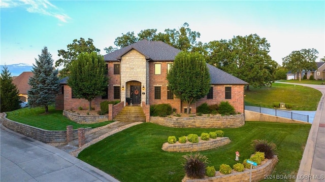 5745 Tree Leaf Ct, Osage Beach, MO 65065 - view of front of house featuring a front lawn, stone siding, and brick siding