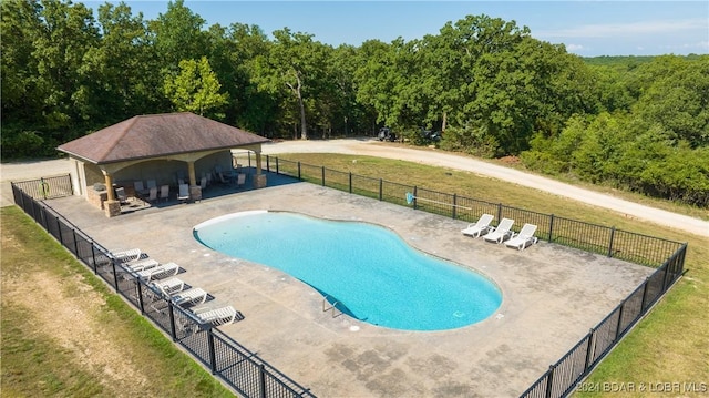 view of pool with a patio and a lawn