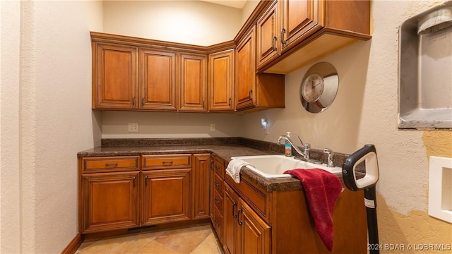 kitchen featuring light tile patterned floors and sink