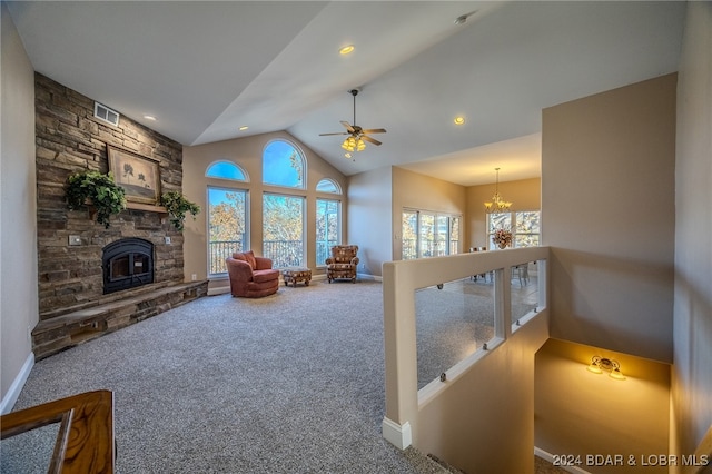 living room featuring carpet flooring, ceiling fan with notable chandelier, high vaulted ceiling, and a fireplace