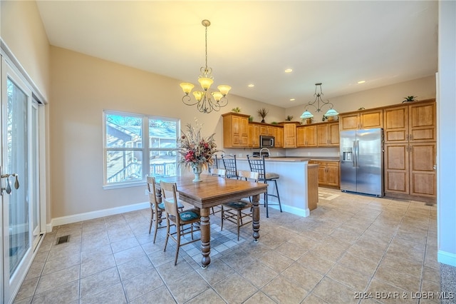 tiled dining room featuring an inviting chandelier