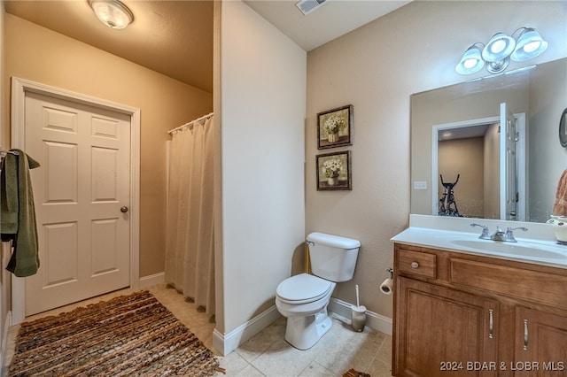 bathroom with tile patterned flooring, vanity, and toilet