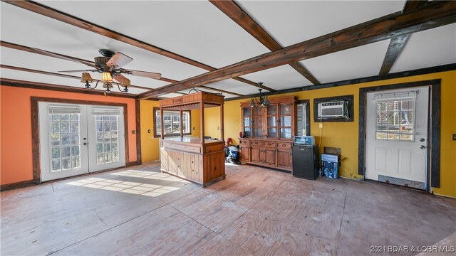 kitchen featuring beamed ceiling, french doors, a wall unit AC, and ceiling fan