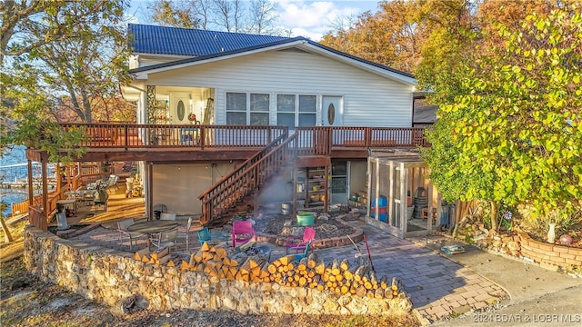 back of property featuring a wooden deck and a patio