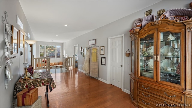 hallway featuring hardwood / wood-style flooring and a notable chandelier