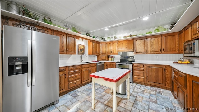 kitchen featuring appliances with stainless steel finishes, backsplash, premium range hood, and sink