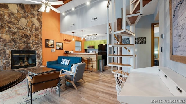 2500 Bay Point Ln Unit 645, Osage Beach, MO 65065 - living area with ceiling fan, a towering ceiling, light wood finished floors, and a stone fireplace