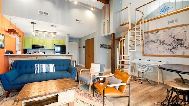 2500 Bay Point Ln Unit 645, Osage Beach, MO 65065 - living area with a towering ceiling, stairs, light wood-style floors, track lighting, and baseboards