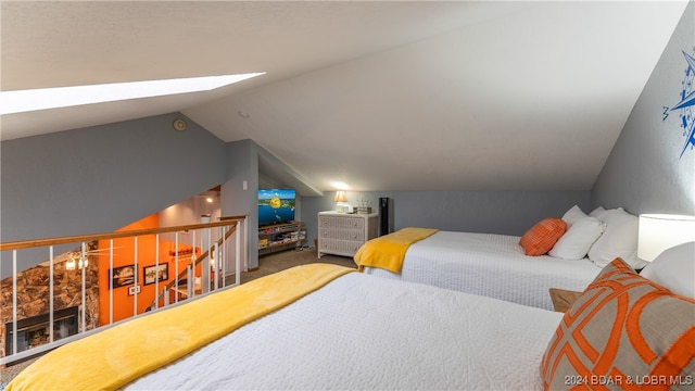 bedroom featuring lofted ceiling with skylight and carpet floors