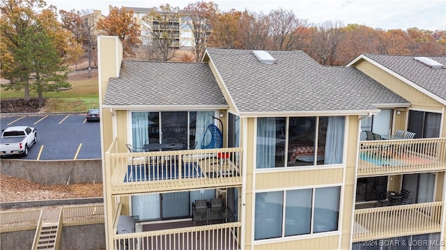 2500 Bay Point Ln Unit 645, Osage Beach, MO 65065 - back of house with uncovered parking and roof with shingles