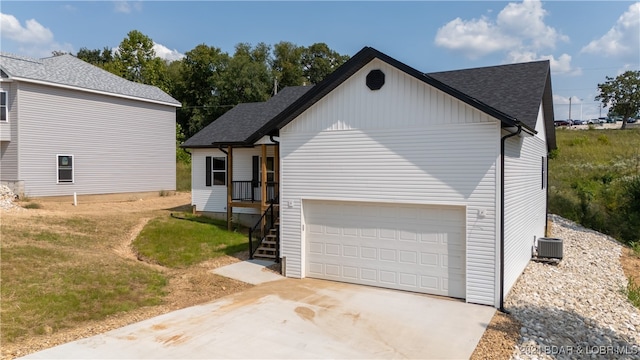 view of side of home featuring a yard, a garage, and cooling unit