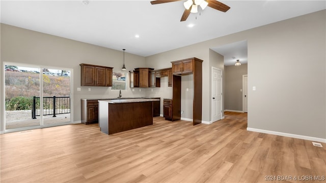 kitchen with a center island, sink, ceiling fan, decorative light fixtures, and light hardwood / wood-style floors