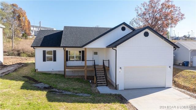 view of front facade with covered porch, a garage, and a front yard