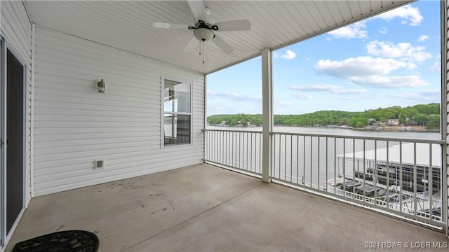 balcony featuring a water view and ceiling fan