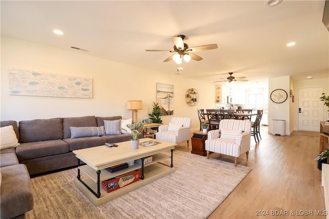 living room with light hardwood / wood-style flooring and ceiling fan