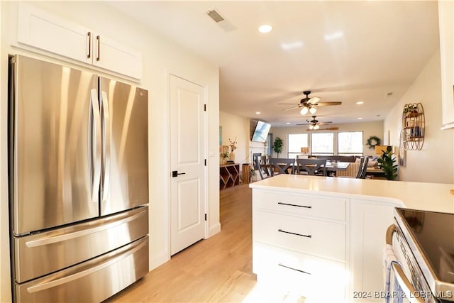 kitchen with stainless steel appliances, white cabinetry, ceiling fan, and light hardwood / wood-style floors