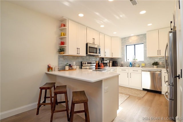 kitchen featuring light wood-type flooring, stainless steel appliances, and white cabinetry