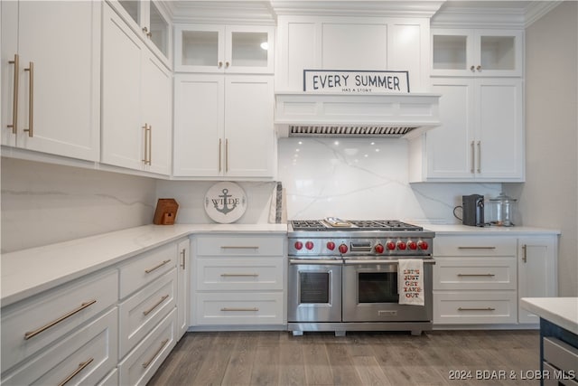 kitchen featuring white cabinets, double oven range, backsplash, and hardwood / wood-style flooring