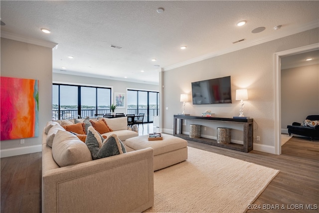 living room featuring a textured ceiling, hardwood / wood-style flooring, and ornamental molding