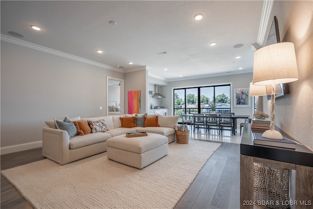 living room featuring a textured ceiling, hardwood / wood-style flooring, and ornamental molding