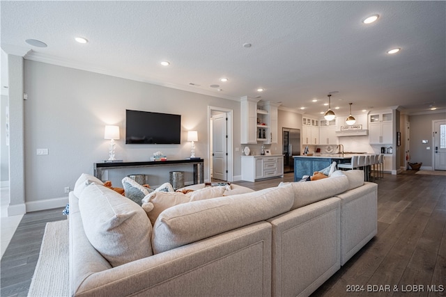 living room featuring dark hardwood / wood-style flooring, ornamental molding, and a textured ceiling