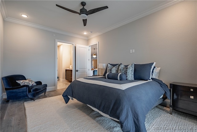 bedroom featuring ceiling fan, ensuite bathroom, wood-type flooring, and ornamental molding