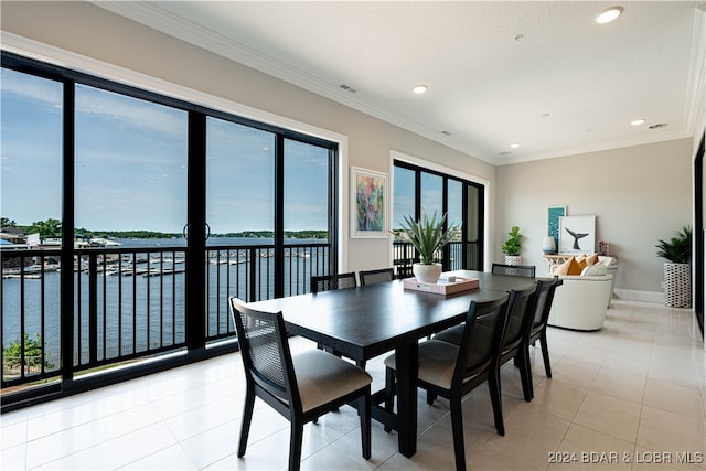 dining area with a water view, light tile patterned floors, and crown molding