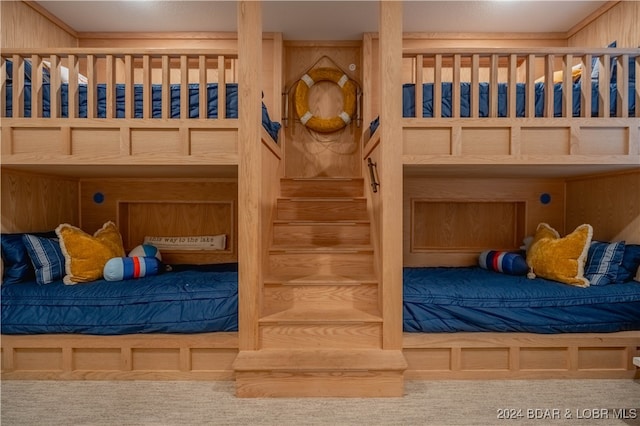 carpeted bedroom featuring ornamental molding and wooden walls