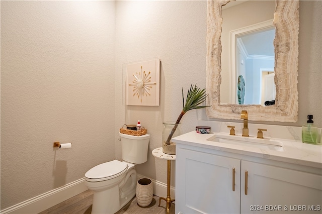 bathroom featuring wood-type flooring, vanity, toilet, and ornamental molding