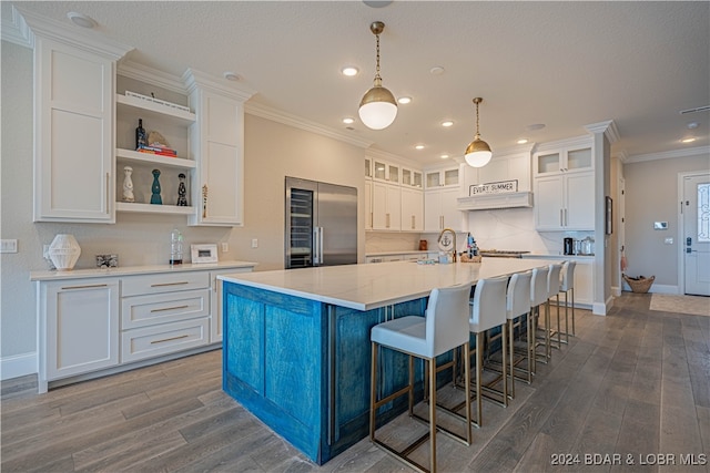 kitchen featuring white cabinetry, built in refrigerator, dark wood-type flooring, and a spacious island