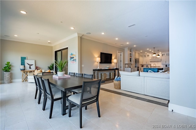 dining area with light tile patterned floors and ornamental molding