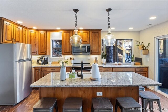 kitchen featuring a breakfast bar area, dark hardwood / wood-style flooring, a center island, and stainless steel appliances