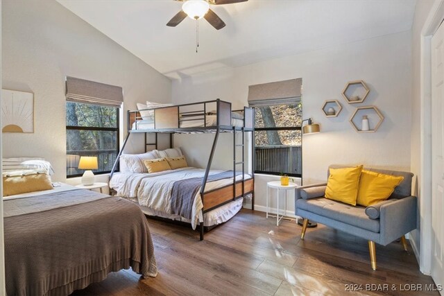 bedroom with hardwood / wood-style floors, vaulted ceiling, and ceiling fan