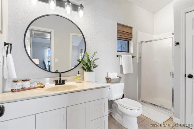 bathroom with tile patterned flooring, vanity, an enclosed shower, and toilet