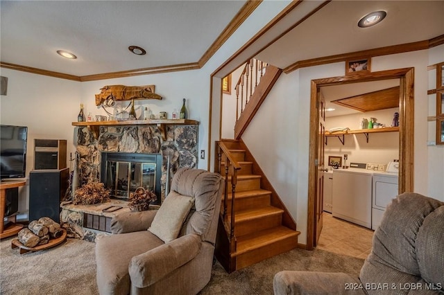 carpeted living room with stairway, ornamental molding, a stone fireplace, and independent washer and dryer